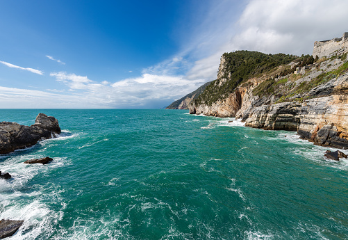 Beautiful bay and rocky cliffs in front of the famous Porto Venere or Portovenere town, Mediterranean and Ligurian Sea, coast fo Cinque Terre National Park (UNESCO world heritage site). La Spezia province, Liguria, Italy, Europe.