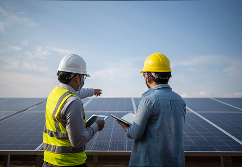 engineer and worker working together in the solar panel power station renewable energy