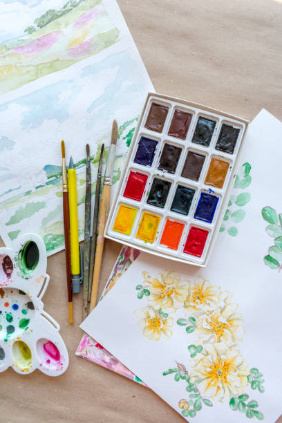 istock Watercolor paints, brushes, palette and drawings 1387474031