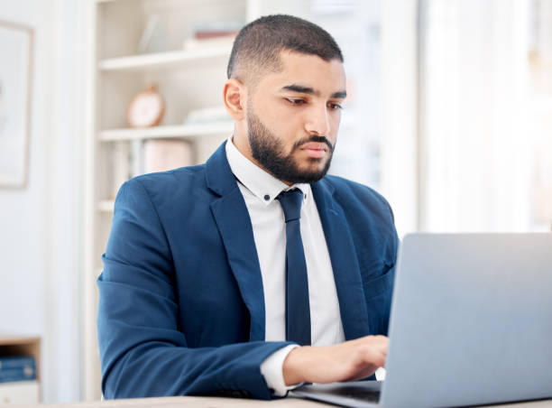 istock Shot of a young businessman using a laptop at work 1387475227