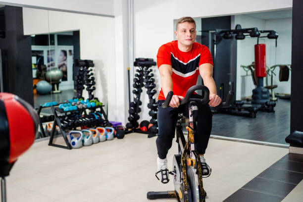 istock Athletic young man cycling on the bicycle exercise machine 1387475469