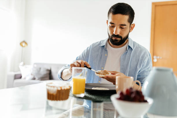 istock Man sitting at the table eating vegan breakfast 1387475865