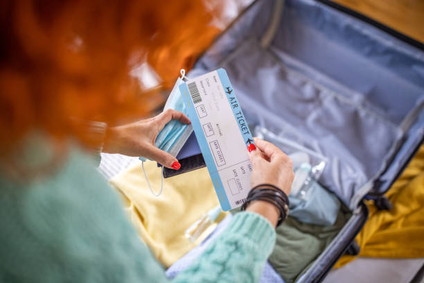 istock Unrecognizable woman looking at her airplane ticket 1387476778