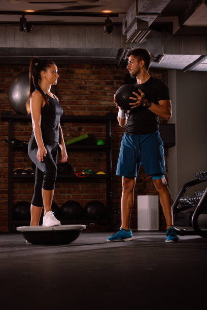 istock Fitness instructor with athlete in a gym 1387477007