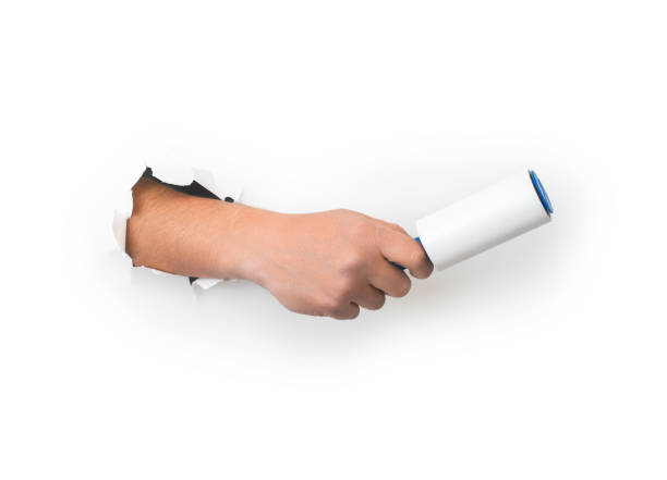 istock Man holding a roller to clean clothes from hair, wool, dust on a white background 1387478338