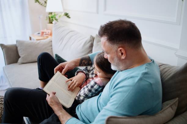 istock Father reading book to his daughter 1387479300