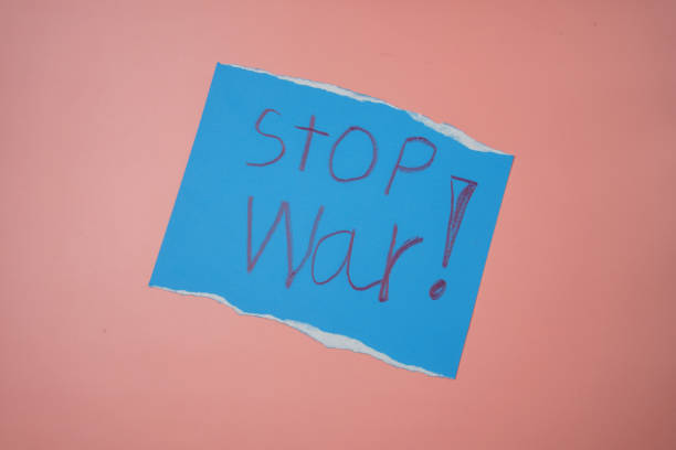 istock Blue paper with the words stop war on a pink background No war, stop war, russian aggression. 1387479481