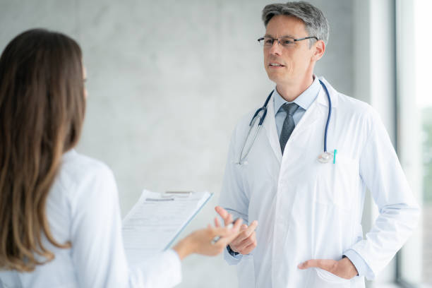 istock Two healthcare workers talking at hospital 1387481042