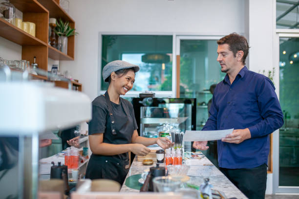 istock happy barista take order with tablet from customer. 1387481173