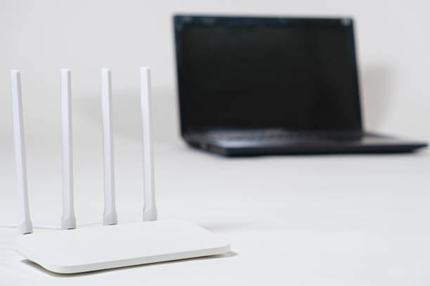 istock Laptop and wi-fi router on a white background. Internet connection. 1387483547