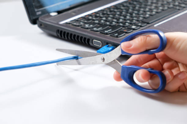 istock Scissors cut the Internet cable connected to the laptop. 1387483563