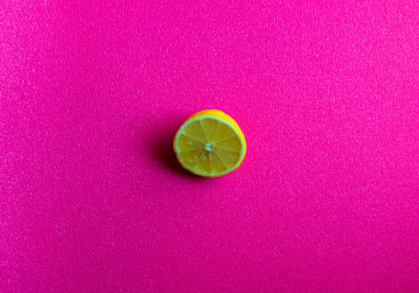 istock Lemon cut in half on bright pink background. Food 1387488081