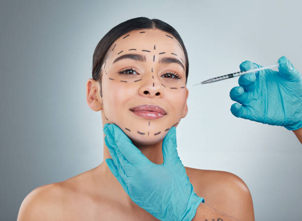 ritratto ritagliato di una giovane donna attraente in posa in studio su uno sfondo grigio - plastic beauty injecting protective glove foto e immagini stock