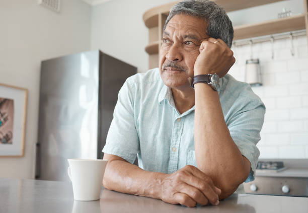 Shot of a senior man looking pensive while drinking coffee at home Being alone gets lonely defeat photos stock pictures, royalty-free photos & images