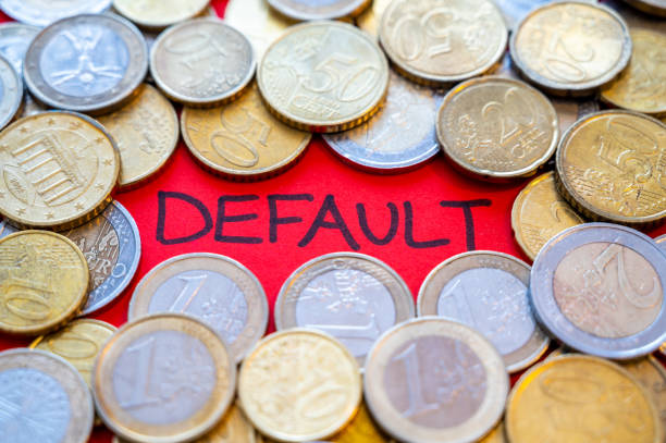 Word "default" on a red background and coins beside it. Economic sanctions, public debt, economy. stock photo