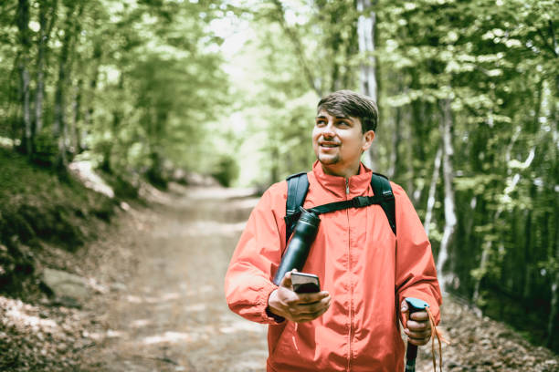 istock Smiling Young Male Enjoying Fresh Air And Forest View While Hiking On Road 1387493475