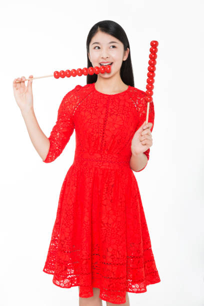 pretty girl wearing a red piece dress holding a sugar-coated haws