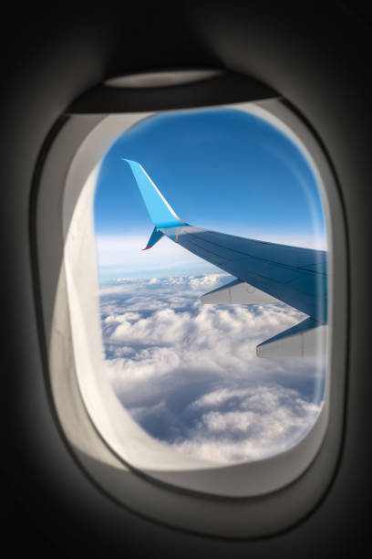 Airliner Flying Above the Clouds Seen Through the Porthole