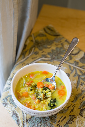 Coconut milk golden lentil turmeric soup with carrots, onion, garlic and kale, gluten free and vegan