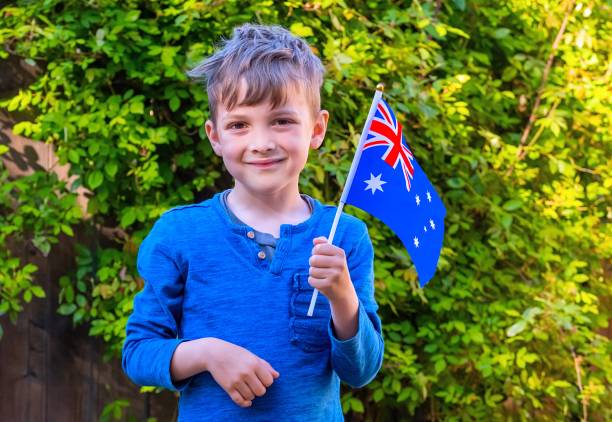 istock Smiling caucasian boy waving an Australian flag looking at the camera 1387498552