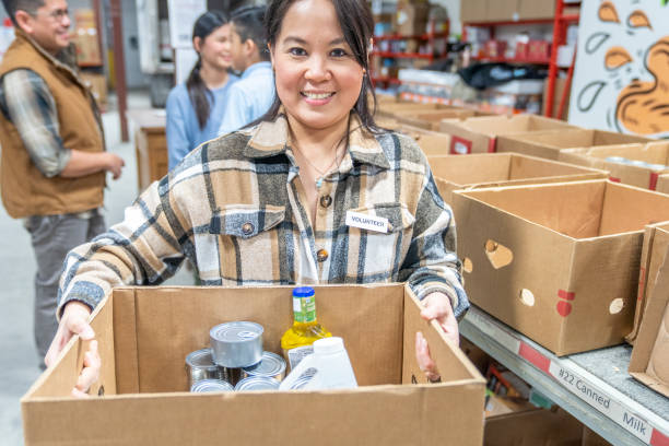 istock Asian Woman Volunteering Her Time 1387498681