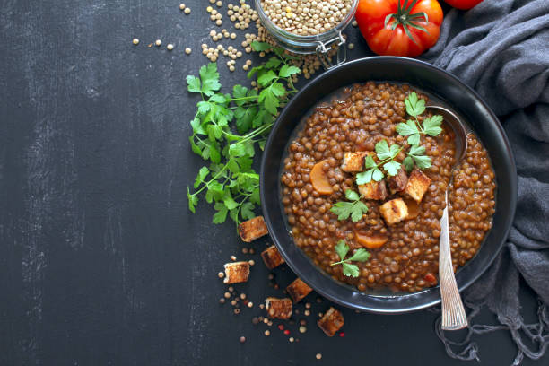 istock Delicious lentils soup served with toaster bread on dark table. 1387500683