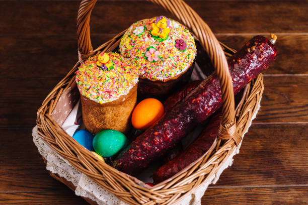 Easter basket with ukrainian easter cake, sausage and Easter eggs on wooden table. Orthodox Easter stock photo