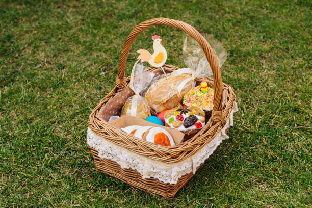 Easter basket with ukrainian easter cake, and Easter eggs on green lawn. Easter chicken figure stock photo
