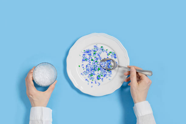 Plate with plastic pieces instead of food and glass of microplastics instead of water. Microplastic problem concept, ocean pollution ecology problem, environmental impact on nature, top view Plate with plastic pieces instead of food and glass of microplastics instead of water. Microplastic problem concept, ocean pollution ecology problem, environmental impact on nature, top view, flat lay microplastic stock pictures, royalty-free photos & images