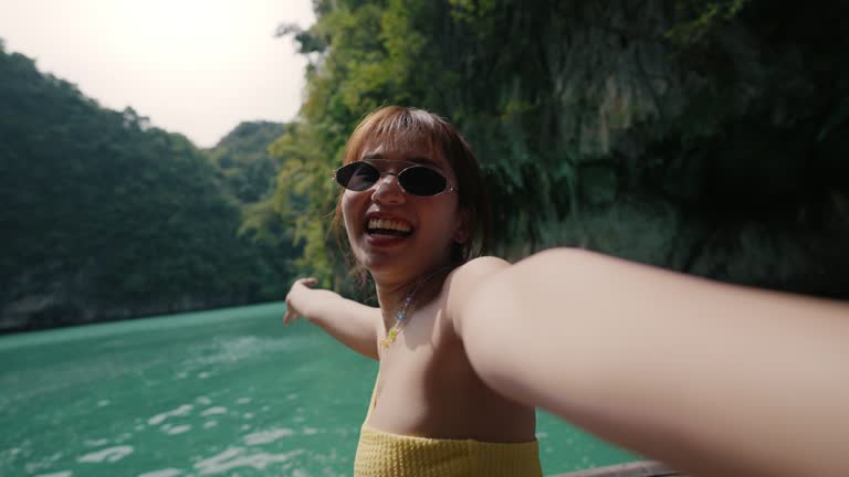 Attractive Asian blogger using smart phone live streaming and upload her journey photos on social media.