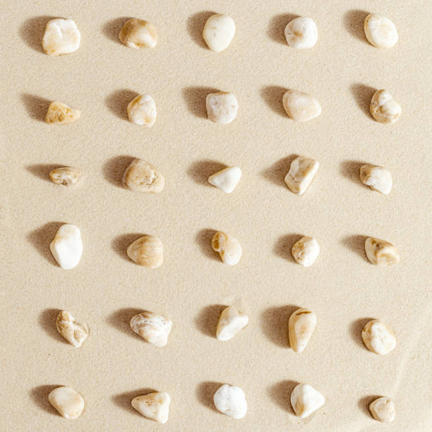 istock Pattern with close up pebble sea stones on sand texture. Layout from natural stone neutral natural tones. Minimal style sandy background 1387503341