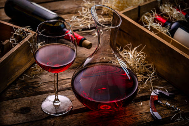 istock Red wineglass and wine decanter on dark table. 1387503889