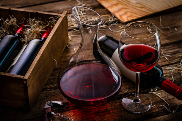istock Red wine and decanter on dark wooden table. 1387503899