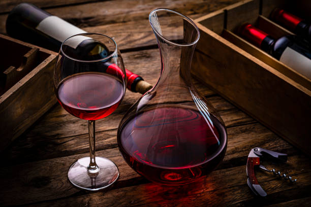istock Red wineglass and wine decanter on dark table. Copy space 1387503909