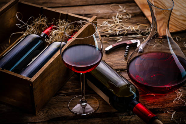istock Decanter, red wineglass and wine bottles on dark table. 1387503923
