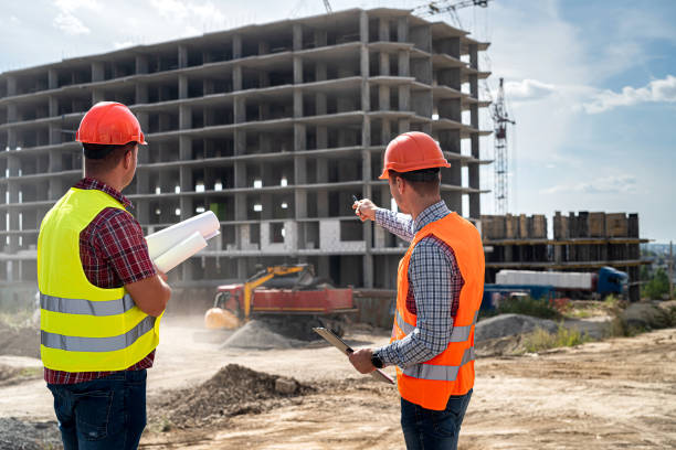 istock two young workers in  uniforms discuss the process of building a house . 1387504705