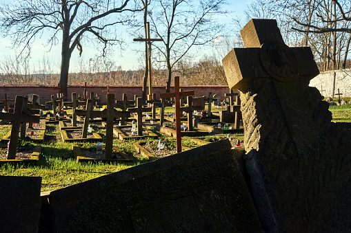 Stone and wooden crosses in an old Catholic cemetery in the village of Owinska in Poland