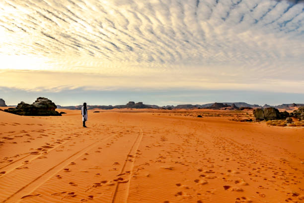 homem tuaregue irreconhecível parado no deserto do saara. - tuareg - fotografias e filmes do acervo