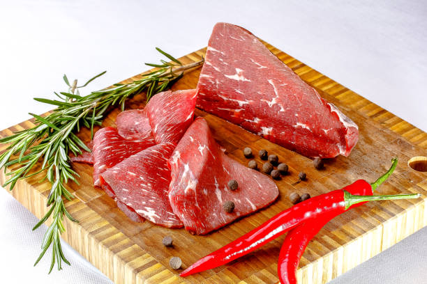 istock Roast beef. Thin slices of raw marbled beef lie on the board. 1387508107