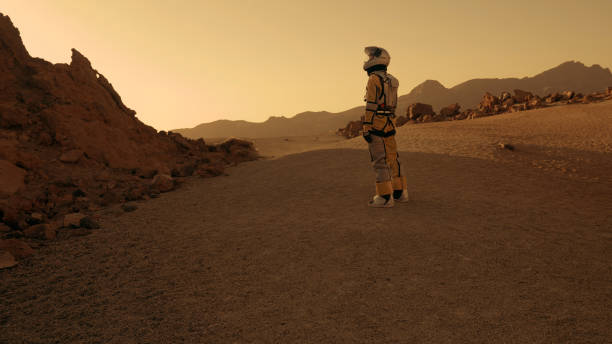 istock A walk on Mars. Female astronaut exploring rust colored desert. Walking towards mountain range 1387508678