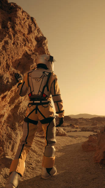 istock A walk on Mars. Female astronaut exploring rust mountains. Climbing on rocks 1387508685