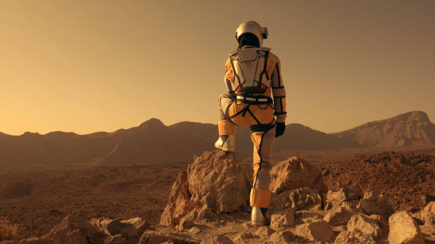 istock A walk on Mars. Female astronaut exploring rust mountains. Climbing on rocks 1387508687
