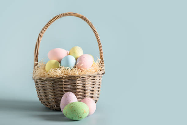 Easter wicker basket with pastel colorful eggs for festive holiday.