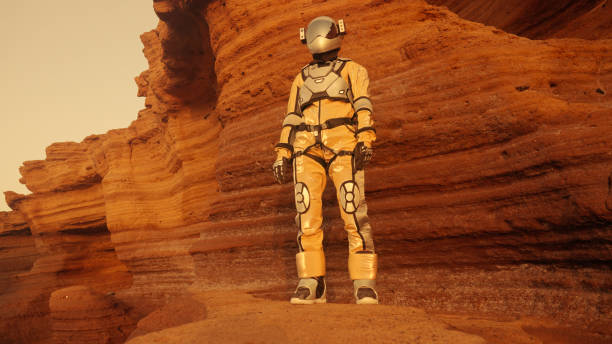 istock A walk on Mars. Female astronaut exploring rust mountains. Climbing on rocks, looking at view 1387509033