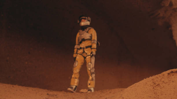 Red dirt on Mars surface. Woman wearing futuristic exoskeleton exploring cave and mountain areas