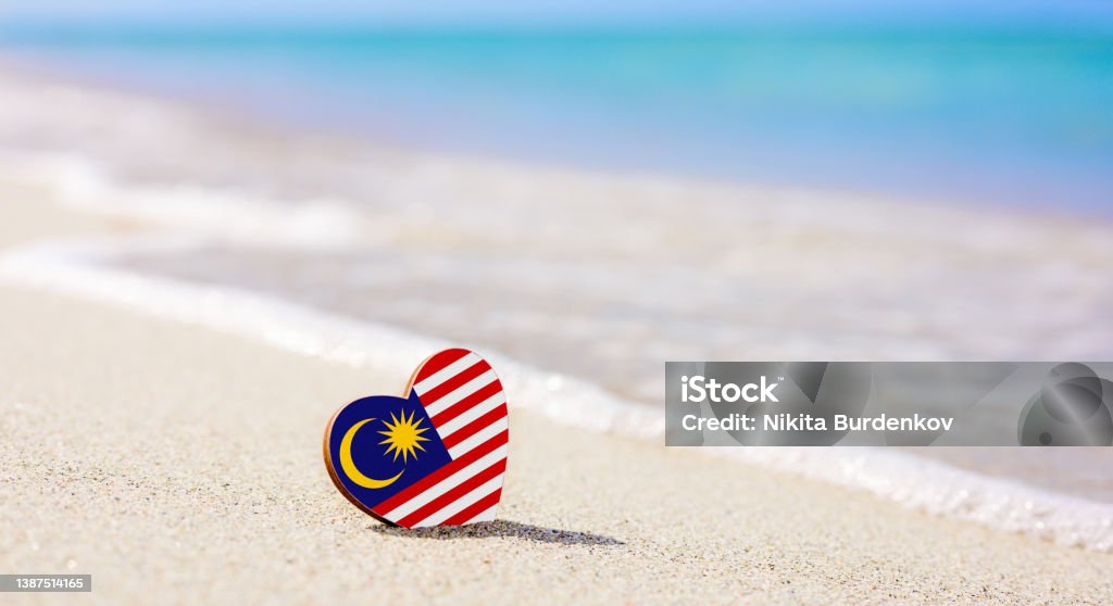 Flag of the Malaysia in the shape of a heart on a sandy beach. Flag of the Malaysia in the shape of a heart on a sandy beach. The concept of the best vacation in Malaysia resorts Asia Stock Photo