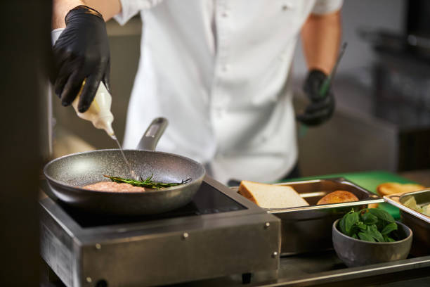 istock Pouring oil on raw beef meat in pan. 1387514166