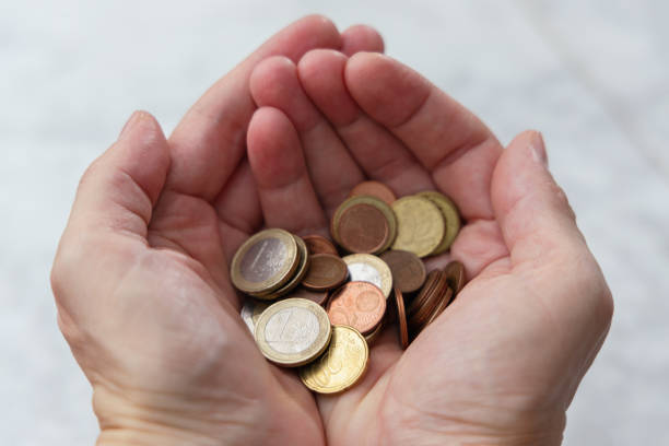 istock Pile of coins in hands. Saving money concept 1387514286