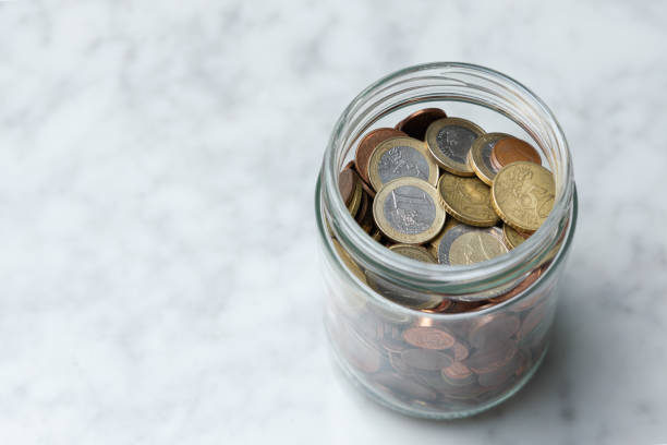 istock Glass jar with coins. Saving money concept 1387514309