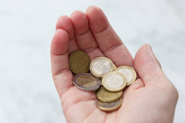 istock Pile of coins in hand. Saving money concept 1387514331